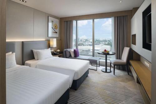 曼谷Asawin Grand Convention Hotel的酒店客房设有两张床和电视。