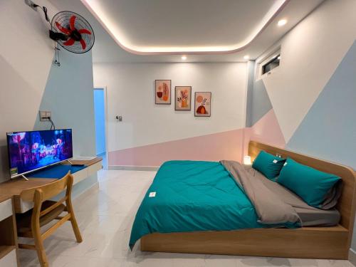 大叻EURO HOUSE的一间卧室配有一张床、一张书桌和一台电视。