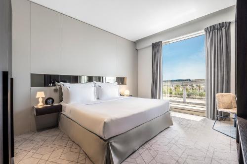 迪拜Studio M Arabian Plaza Hotel & Hotel Apartments的一间卧室设有一张大床和一个大窗户