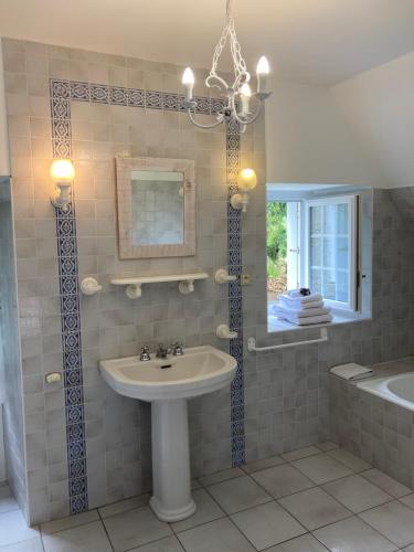 MalansacManoir de Saint-Fiacre的一间带水槽、浴缸和镜子的浴室