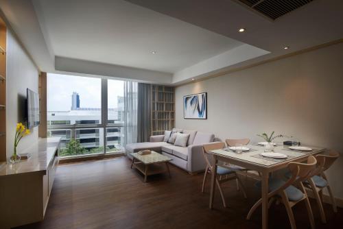 曼谷曼谷碧武里47莎玛服務式公寓的客厅配有桌子和沙发