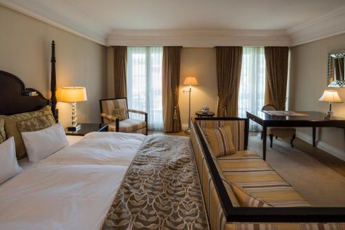 沃尔特湖畔韦尔登韦尔登富肯斯坦纳城堡酒店-世界顶级酒店集团的酒店客房设有一张大床和一张书桌。