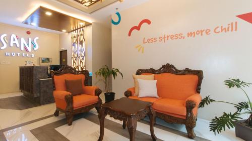 马尼拉Sans Hotel at Algers Suites Marikina by RedDoorz的商店里两把椅子和一张桌子