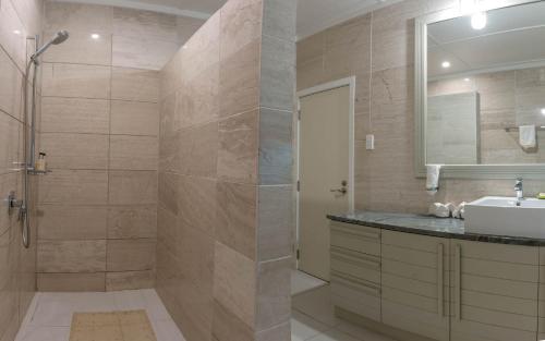 拉罗汤加穆里海滩别墅的带淋浴、盥洗盆和镜子的浴室