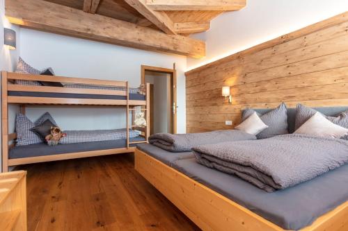翁肯Moarhof的卧室设有两张双层床,卧室设有木墙