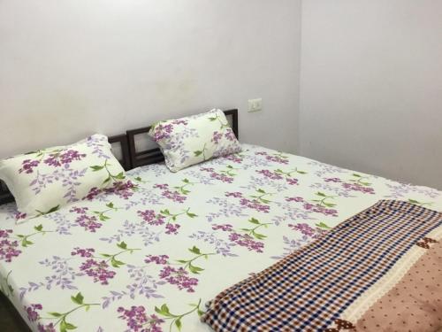 BokāroHOTEL SWAGAT的一张带紫色鲜花和两个枕头的床
