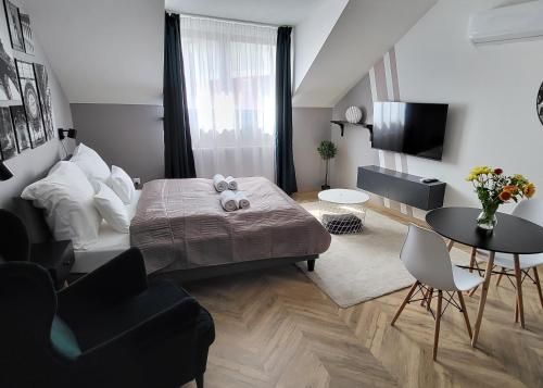 塔塔Dotis Apartman Tata的卧室配有一张床和一张桌子及椅子