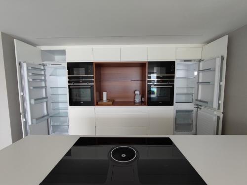 比纳罗斯VILLA EULALIA的厨房配有白色橱柜和黑色地板