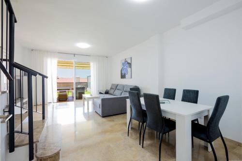 圣地亚哥港Residencial Playa de La Arena的用餐室以及带白色桌椅的起居室。