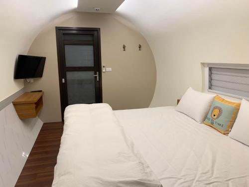 埔里星玥涵屋的卧室配有白色的床和电视。