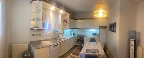 普拉奇里奥Villa Ariadni的厨房配有白色橱柜和水槽