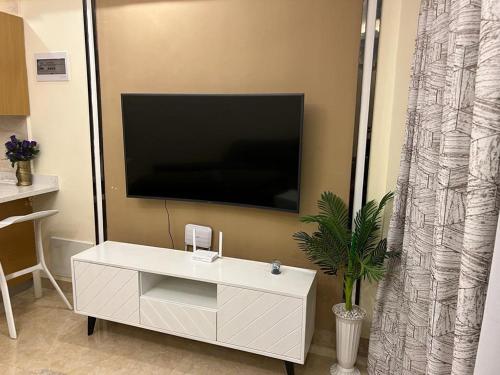 内罗毕Enzi Heights Apartment Block B的客厅配有白色橱柜和平面电视。