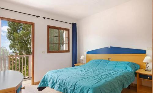 圣卢西亚Holiday Cottage Santa Lucía 1的一间卧室设有蓝色的床和一个阳台