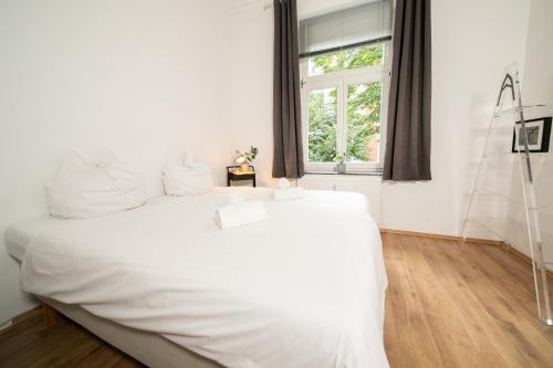 杜塞尔多夫WHITE 60 QM Apartment - Zentral - Balkon - Messe的窗户客房内的一张白色床