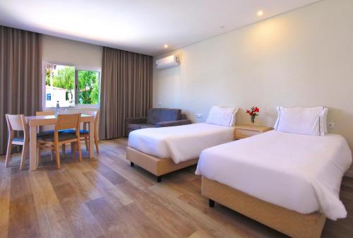 拉戈斯Agua Hotels Vila Branca的酒店客房设有两张床和一张桌子。