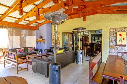 博克斯堡非洲精品酒店​​O.坦博的客厅配有家具和木制天花板。