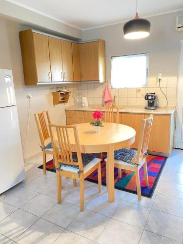 卡瓦拉KOLOKOTRONIS’ HOUSE的厨房配有木桌、椅子和冰箱。