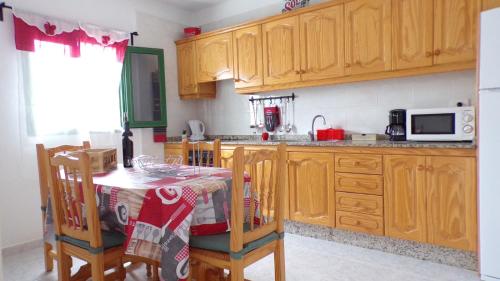 阿里亚CASA LITO的厨房配有木制橱柜和桌椅