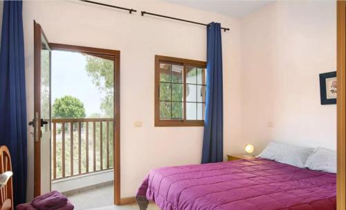 圣卢西亚Holiday Cottage Santa Lucía 2的一间带紫色床的卧室和一个阳台