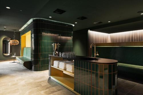 艾森斯塔特Hotel Galántha的浴室拥有绿色的墙壁,配有带毛巾的台面