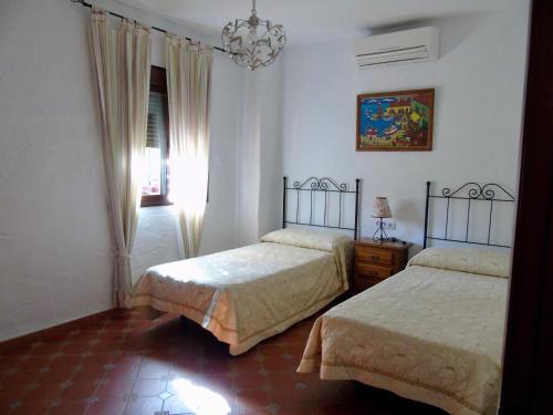 埃尔加斯托尔Balcón al Valle的一间卧室配有两张床和吊灯。