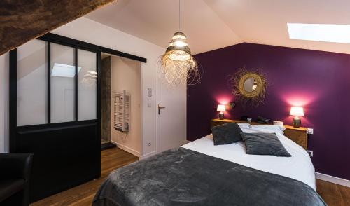 内拉克Les Gîtes du château - L Appartement du Roi - Magnifique Appartement face au château的一间卧室设有紫色的墙壁和一张大床