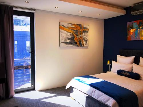 开普敦Queen Julie Lodge的一间卧室设有一张床和一个大窗户