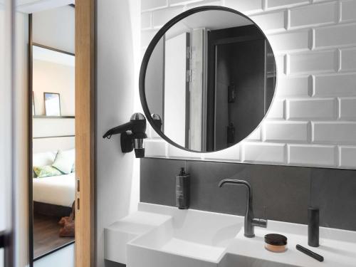 布鲁塞尔都会大酒店的一间带水槽和镜子的浴室