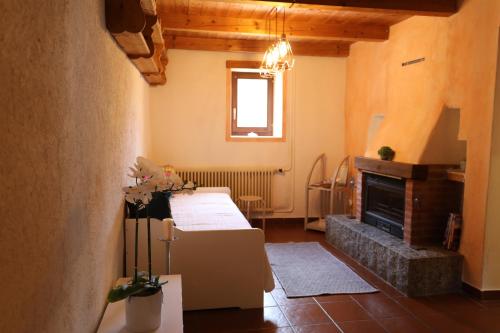 卢加诺Casa Holamundo - romantisches Tessiner Steinhaus (vegi)的客厅设有两张床和壁炉