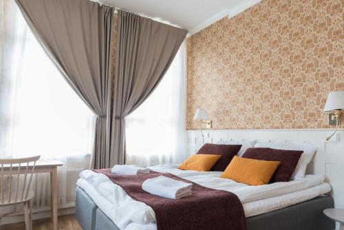 拉彭兰塔Boutique Hotel Lähde的一间卧室配有一张带橙色枕头的大床