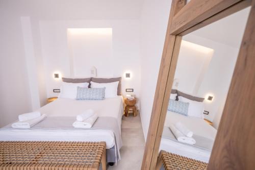 安迪帕罗斯岛克洛斯村旅馆的一间卧室配有两张床和镜子