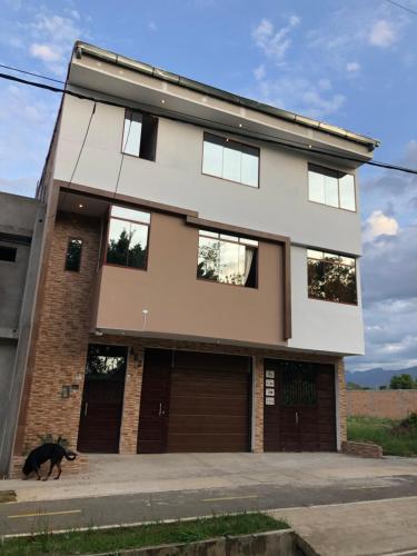 塔拉波托CASA SHILCAYO Habitaciones Vacacionales的一只黑狗在房子前走