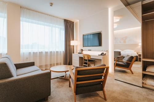 塔林多尔帕特温泉&会议酒店的客厅配有沙发和书桌及电视