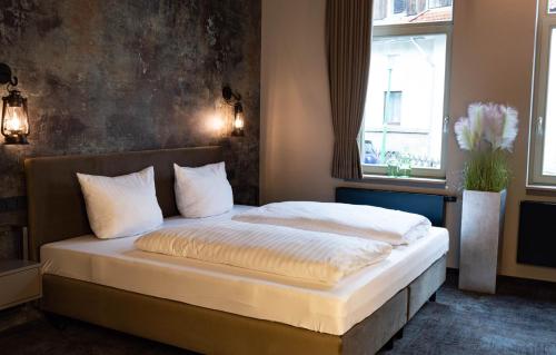布劳恩拉格StrandBerg's B&B Oma Ida的一间卧室配有一张带白色床单的床和一扇窗户。