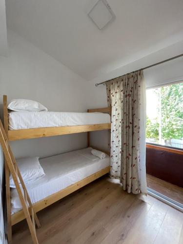 地拉那Ladi Rooms的客房设有两张双层床和一扇窗户。