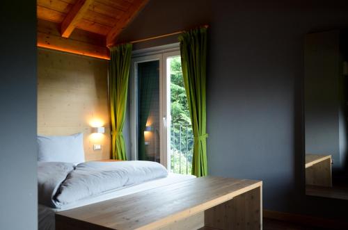 罗恩佐Hotel Villa Argentina Ronzone的一间卧室设有一张床和一个窗口
