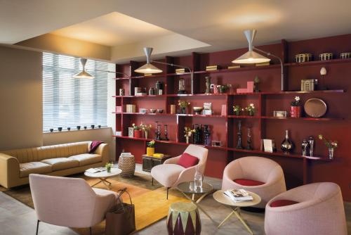 里昂里昂拉法叶蓬奥考酒店的客厅配有沙发、椅子和书架
