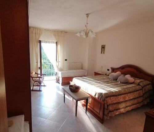 Laino BorgoIl casale dell'artista的一间卧室配有一张大床和一张桌子