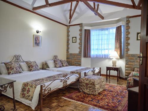 内罗毕The Drexel House Kenya的一间卧室配有一张床、一张沙发和一个窗口