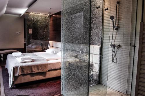马里博尔Hotel Lent superior的带淋浴的浴室和客房内的一张床