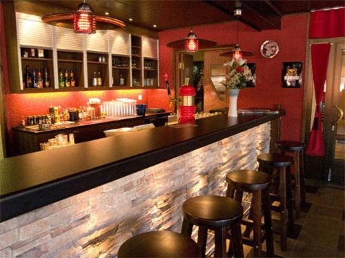 HaapavesiHotelli Haapakannel的红墙餐厅内带凳子的酒吧