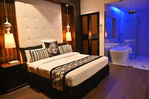 麦纳麦Ista Suites Seef的一间带大床的卧室和一间带浴缸的浴室