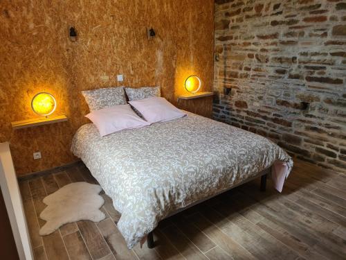 ChamprépusGîte de L'Hotel Mahey的卧室配有一张带两盏灯的墙壁床。