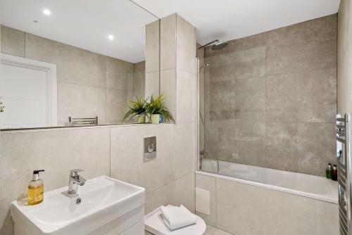 沃特福德The Arches Watford的浴室配有盥洗盆、卫生间和浴缸。