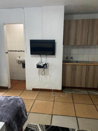 索韦托Soweto Towers Guest Accommodation的一间在浴室墙上配有电视的房间