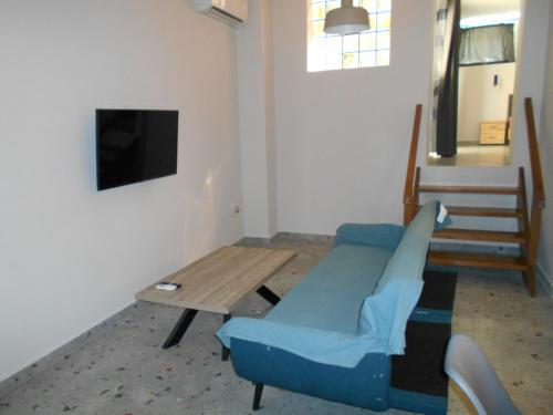 皮洛斯SPΛCES PYLOS Apartments的客厅配有桌子和蓝色沙发