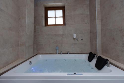 普里兹伦Hotel Castello的带窗户的浴室内的白色大浴缸