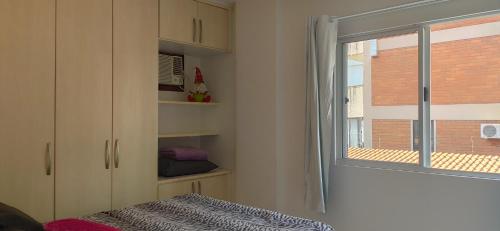 巴拉奈里奥-坎布里乌Incrível apartamento Balneário Camboriú的一间卧室设有窗户和一张带毯子的床