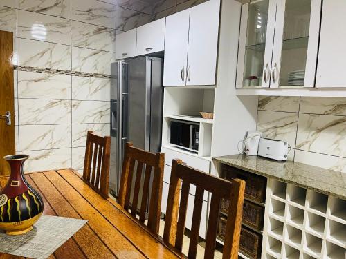 马普托Januario Maputo的厨房配有白色橱柜和桌椅