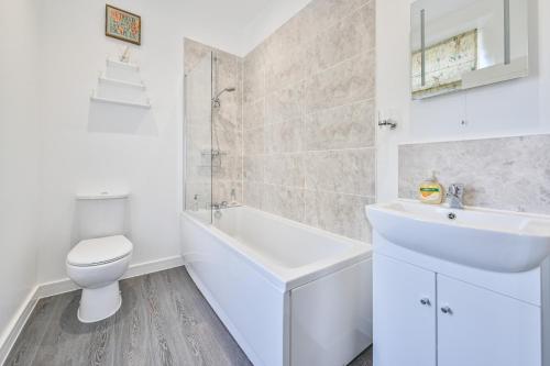 托基The Falstone Apartment的白色的浴室设有水槽和卫生间。